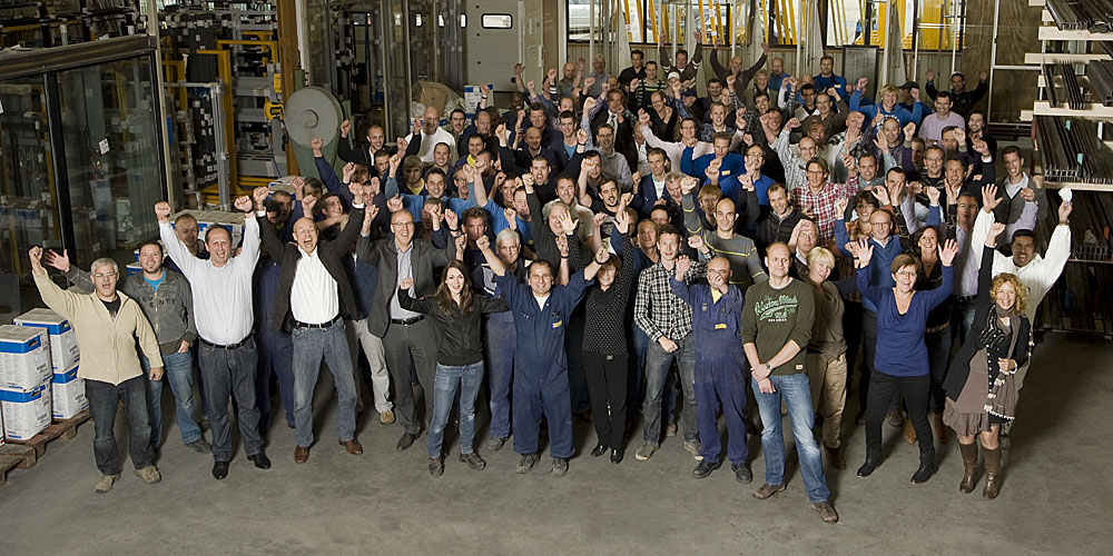 A group photo of all MHB employees inside the factory, cheering